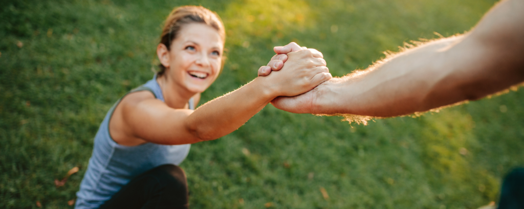 Photo of one person helping another up