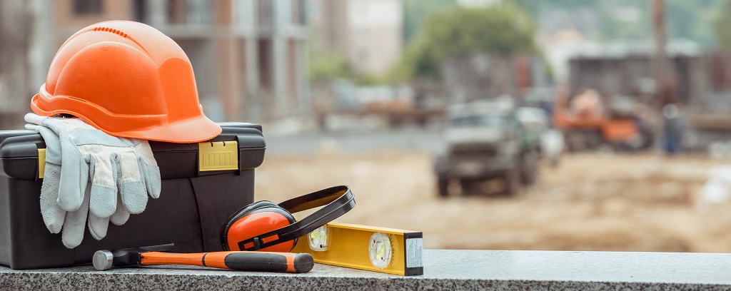 Photo of helmet, gloves, hearing protection, etc. at construction site