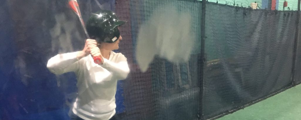 Photo of Nance L. Schick standing in a batting cage ready to hit the ball: helmet on, elbows bent, proper stance and focus.