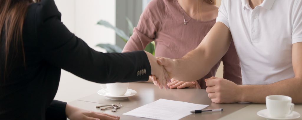 Photo of two clients shaking hands with their attorney.
