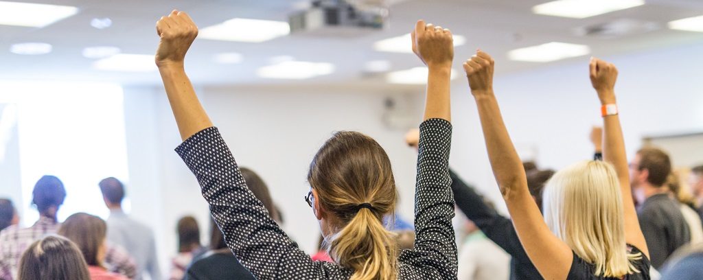 Photography of employees raising both of their arms overhead in an empowering way. Employment partnership is empowering for employer and employee.