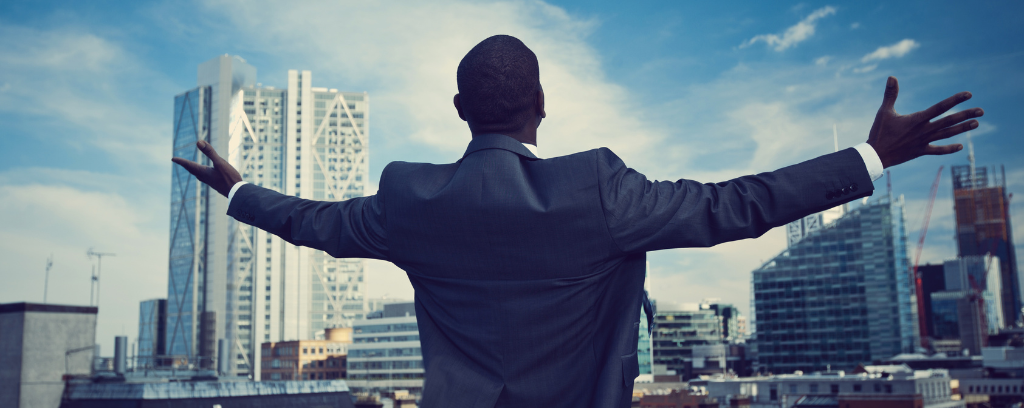 Photo of business person with outstretched arms, signaling freedom