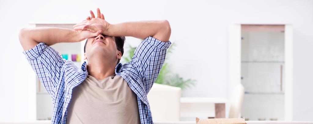 Photo of frustrated person with head back, arms above head, and hands covering face