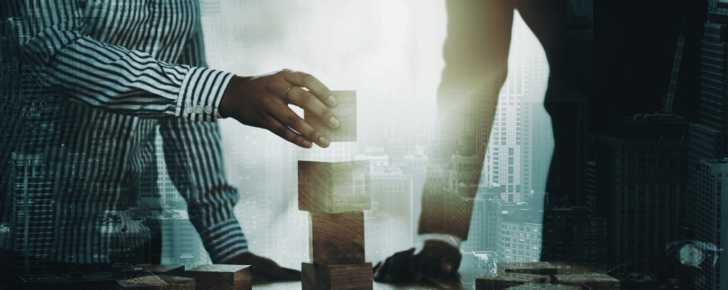 Photo of two professionals stacking building blocks on a table