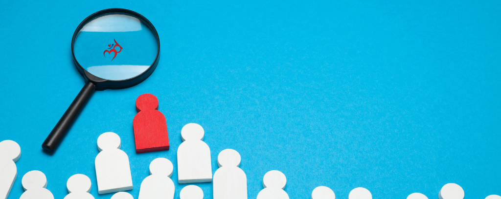 Photo of magnifying glass on blue background with white shapes representing people and one red person shape