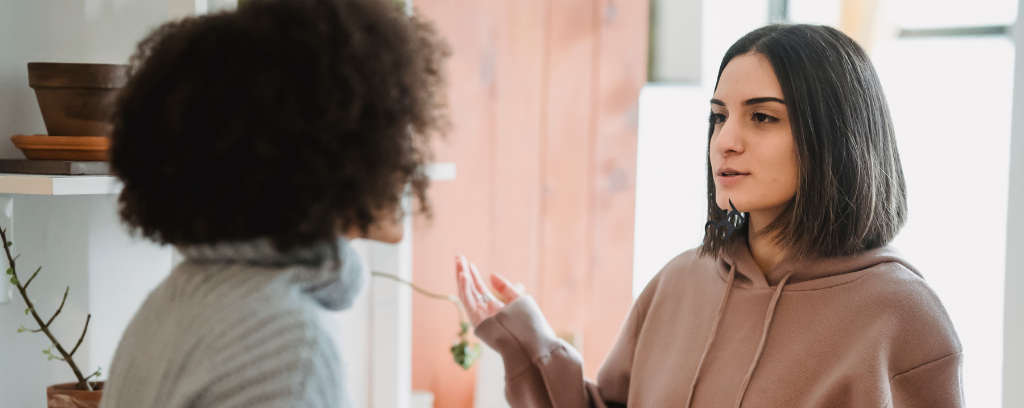 Photo of two employees from different ethnic backgrounds arguing at work
