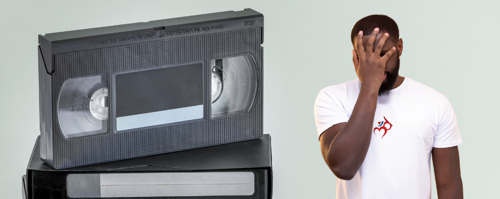 Photo of old VHS tapes next to employee in Third Ear Conflict Resolution T-shirt expressing dismay about ineffective workplace training videos