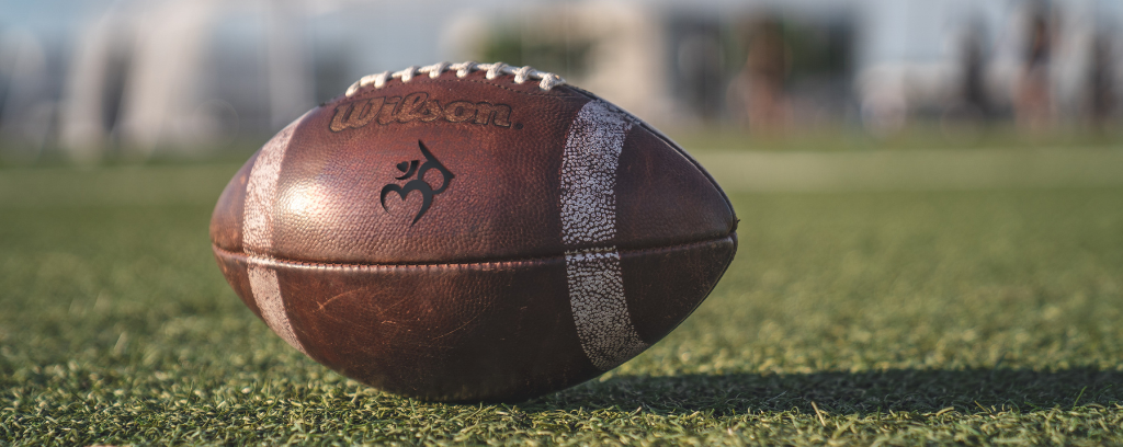 Photo of football on field with Third Ear CR logo